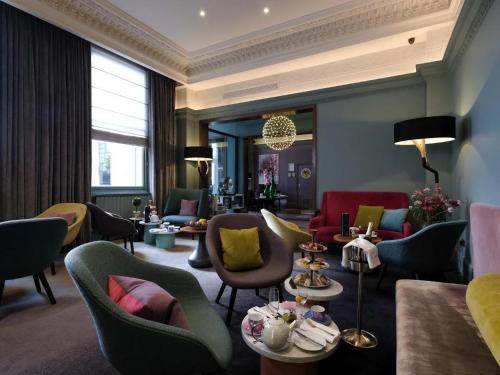 a hotel room with chairs and tables and a lobby at The Chapter Hotels -Lancaster Gate in London