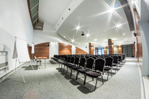 a conference room with black chairs in a white room at Hotel Tychy in Tychy