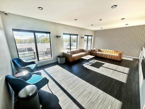 a living room with a couch and chairs and a table at Monochrome Den in Des Moines