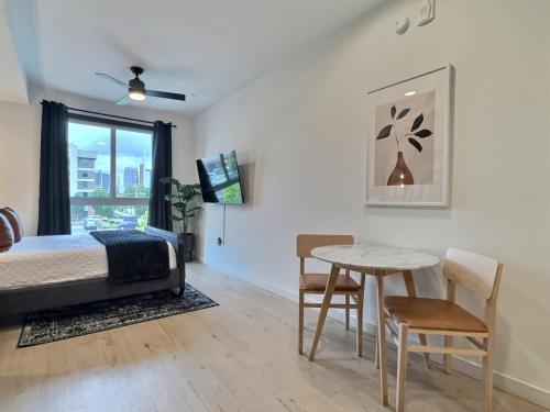 伯明翰Railroad Park Reset, Modern Space的一间卧室，里面有一张床、一张桌子和几把椅子。