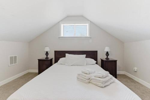 Un dormitorio con una cama blanca con toallas. en The Hideout Loft - Tranquil Stay, en Memphis