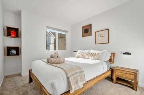 Single Detached Full House with Ping Pong King Bed and Garage في إيدمونتون: غرفة نوم بيضاء مع سرير مع دمية دب عليها