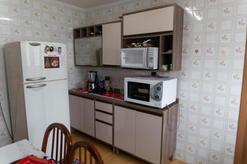 una cucina con frigorifero bianco e forno a microonde di Apto Pet Friendly c Estacionamento perto do Centro a Caxias do Sul