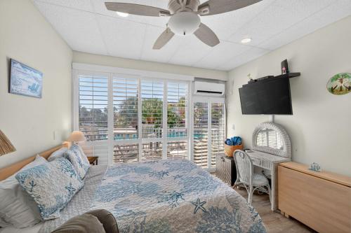 een slaapkamer met een bed en een flatscreen-tv bij Belleview Gulf Unit 395 in Clearwater Beach