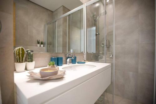 Un baño con lavabo blanco y ducha en Nautica 2-BR Apt & Balcony at Waterfront in Dbaye, en Dbayeh