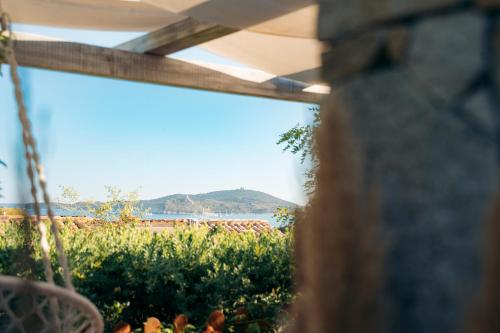 a view of a field from a window of a garden at Dimora Su Tramonti a due passi dal mare! in Is Traias
