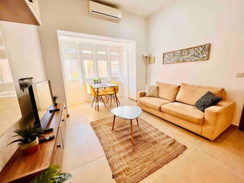un soggiorno con un divano e un tavolo di Sunny house by the sea a Taʼ Xbiex