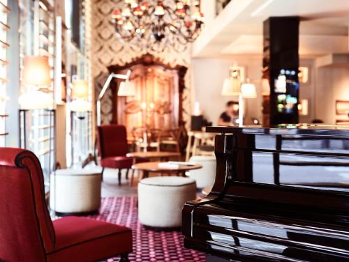 a hotel lobby with a piano and chairs and a chandelier at Hotel Villa Emilia in Barcelona
