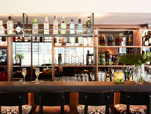 a bar with wine glasses and bottles on shelves at Hotel Villa Emilia in Barcelona