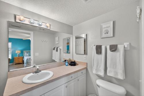 a bathroom with a sink and a toilet and a mirror at Captains Cove Unit 402 in Clearwater Beach