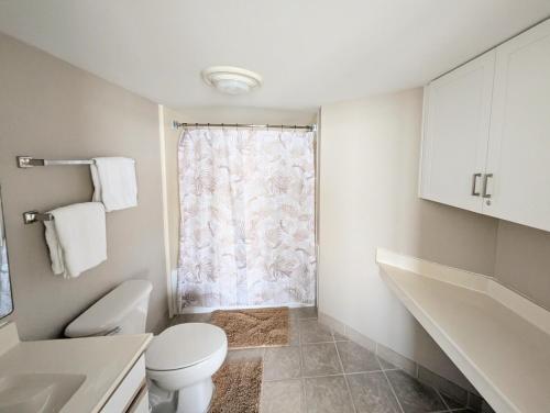 a white bathroom with a toilet and a window at Beautiful Beachfront 2BR2Bath & 2 Balconies in North Myrtle Beach