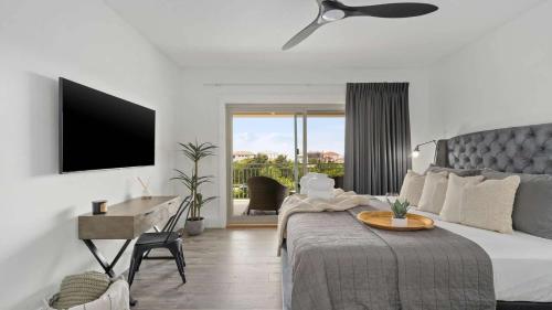 a bedroom with a bed with a table and a television at Inn at Seacrest Beach 408 in Rosemary Beach