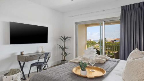 a bedroom with a bed with a table and a television at Inn at Seacrest Beach 408 in Rosemary Beach