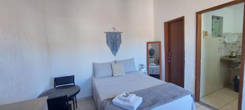 una camera da letto con un letto, un tavolo e uno specchio di Quitinete pé na praia Ap 201 a Rio das Ostras