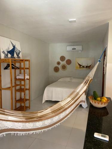 a hammock in a bedroom with a bed at Casa Juba in Camocim