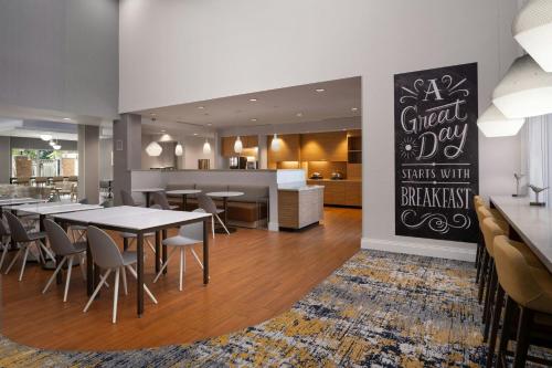 a dining room with tables and chairs and a kitchen at TownePlace Suites by Marriott Phoenix Chandler/Fashion Center in Chandler