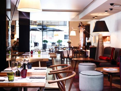 a restaurant with wooden tables and chairs and a room filled with tables at Hotel Villa Emilia in Barcelona
