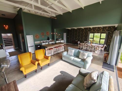 a living room with a couch and chairs and a kitchen at Beautiful Breakaway in Champagne Valley