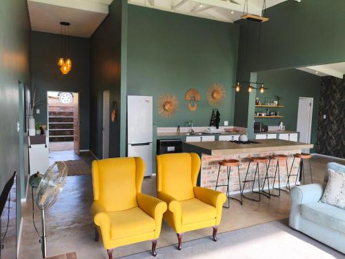 a kitchen with yellow chairs and a kitchen island at Beautiful Breakaway in Champagne Valley