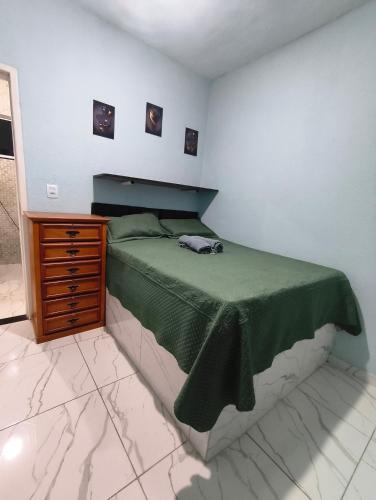 a bedroom with a bed and a wooden dresser at Recanto do Coral in Cabo Frio