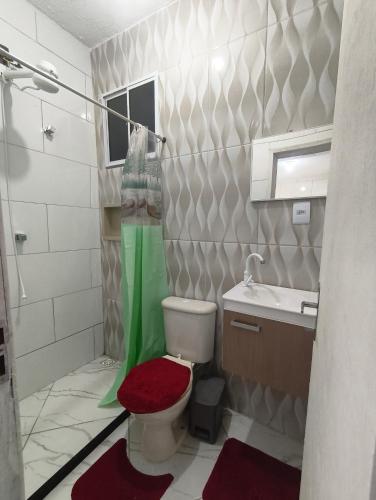 a bathroom with a toilet and a sink at Recanto do Coral in Cabo Frio