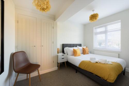 a bedroom with a large bed and a chair at Perfect 3 Bedroom Banbury Accommodation for Contractors! in Banbury