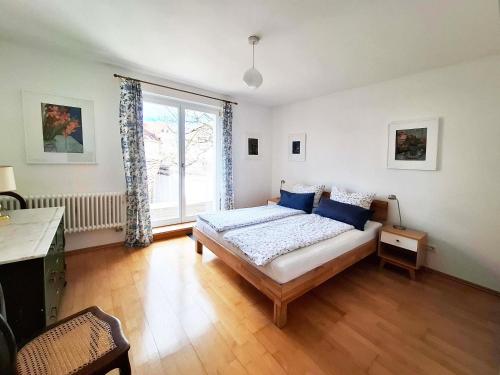 a bedroom with a bed with blue pillows and a window at Schlößleweg 2a in Bodman-Ludwigshafen