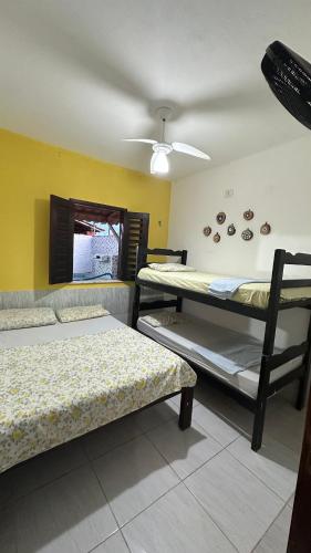 a room with three bunk beds and a ceiling at Residência Tatiane canoa in Canoa Quebrada