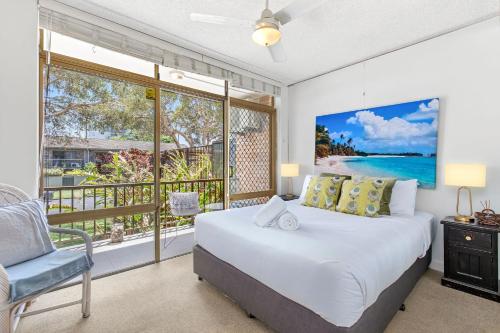 una camera da letto con un letto e una grande finestra di Relaxed Beachside Escape on the Ground Floor Sandcastles 201 a Coffs Harbour