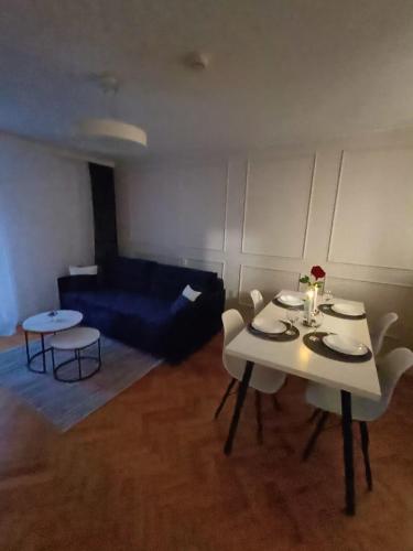 a living room with a table and chairs and a couch at Apartament Aksamitny in Toruń