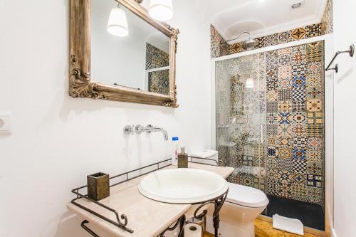 un bagno con lavandino e specchio di Pateo Boaventura in Bairro Alto a Lisbona