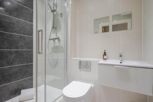 a bathroom with a shower and a toilet and a sink at Luxury Parkway Apartment in Chelmsford City in Chelmsford