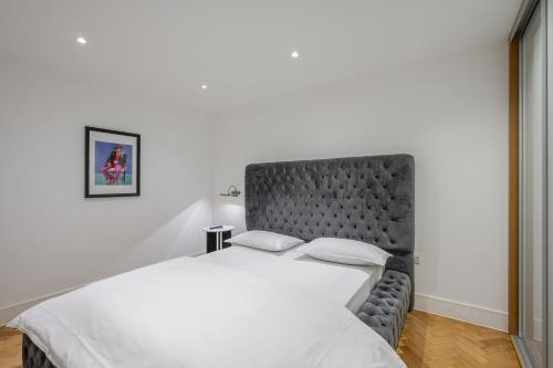 a bedroom with a large bed with a black headboard at Luxury Parkway Apartment in Chelmsford City in Chelmsford
