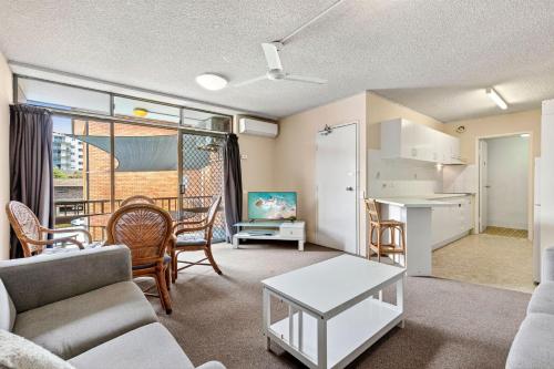 un soggiorno con un divano e un tavolo di Beachside Retreat with Resort Pool & Spa Access Sandcastles 224 a Coffs Harbour