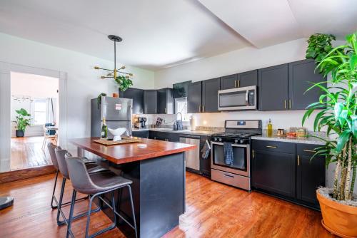 a kitchen with black cabinets and a wooden counter top at Jungle House Columbus Downtown Free Parking Sleeps 8 - Walk to Convention Center & Nationwide Arena - 2BR Short North Luxury Home - Over 5,800 Five Star Stays in Columbus