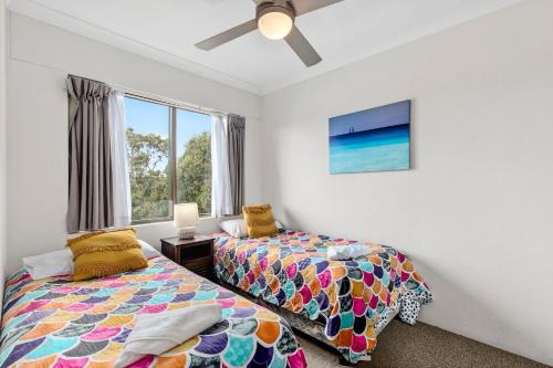 una camera da letto con due letti e una finestra di Beachside Escape with Resort Facilities Sandcastles 226 a Coffs Harbour