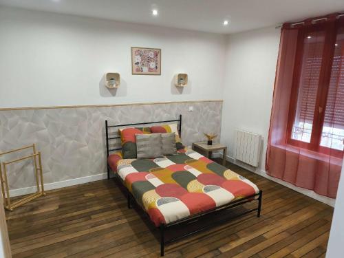 a bedroom with a bed and a red window at Cozy Studio avec Parking Charleville in Charleville-Mézières