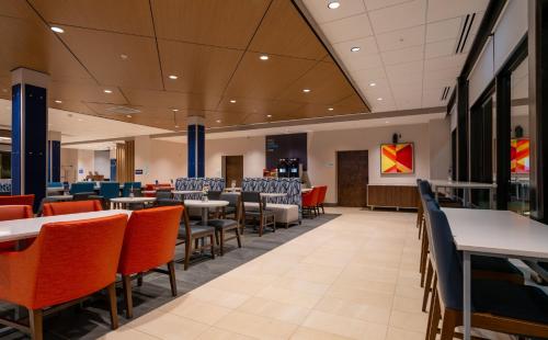 a dining area with tables and chairs in a cafeteria at Holiday Inn Express & Suites Murfreesboro West by IHG in Murfreesboro