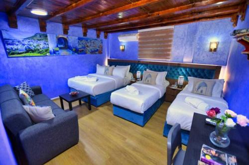 Hotel Dar Annasr في شفشاون: غرفة زرقاء بسريرين واريكة