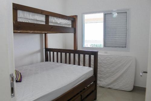 a bedroom with two bunk beds and a window at cozy apartment in the center of Bertioga in Bertioga