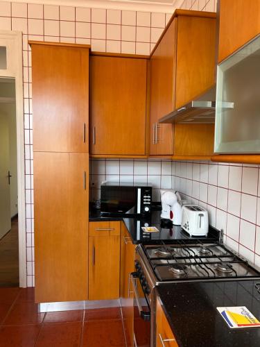 una cucina con mobili in legno e un forno a piano cottura di GARDEN VIEW APARTMENT a Horta