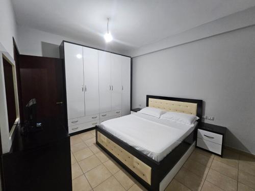 1 dormitorio con 1 cama y armarios blancos en Apartamente Noel Vlore, en Vlorë
