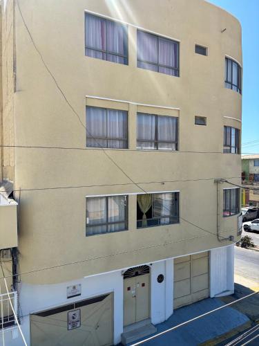 un edificio alto con due garage di fronte di Hotel Veas ad Antofagasta
