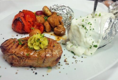 a plate of food with a piece of meat and potatoes at Hotel Meyerhoff in Ostrhauderfehn
