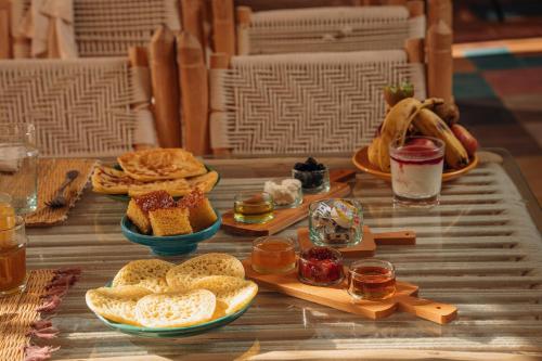 El KariaOxygen Lodge Agafay的餐桌上放有面包和其他食物的盘子