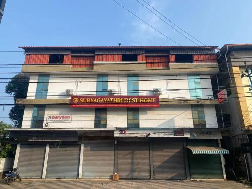Un edificio con un cartel al costado. en Suryagayathri Rest Home Kozhikode, en Kozhikode