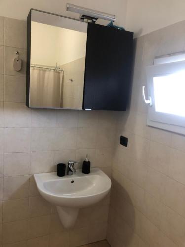 a bathroom with a white sink and a mirror at Dimora CentoDue in Bari