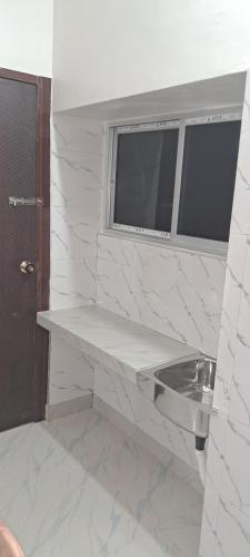 a bathroom with a sink and a window at Diya STAYS in Rāmpur Hāt
