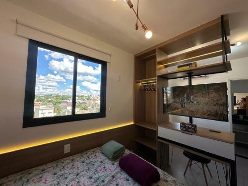 a bedroom with a bed and a large window at TESLA APT2-Pool, Air, gym, 24-hour portaria in São Carlos