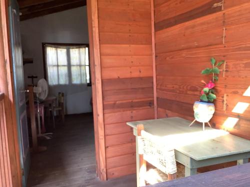 a room with a wooden wall with a table at Katary Gro Ecohotel in Marquelia